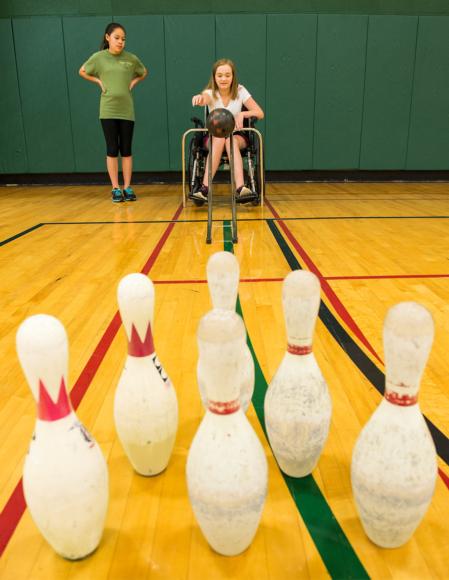 This student is learning the prerequisite skills for bowling in the community.