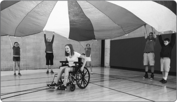 Figure 3.1 As noted in the text, the parachute can be used in inclusive activities in many ways. Here, a student using a wheelchair is easily included.